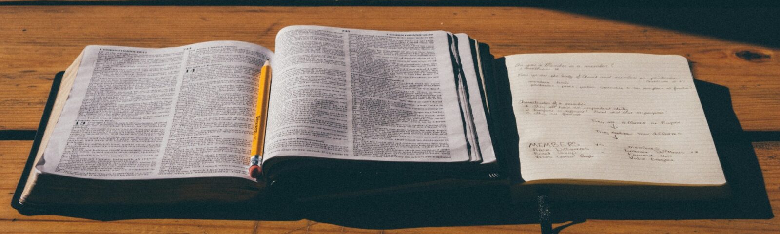 Bibel med anteckningshäfte bredvid.