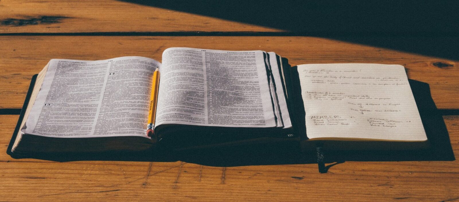 Bibel med anteckningshäfte bredvid.
